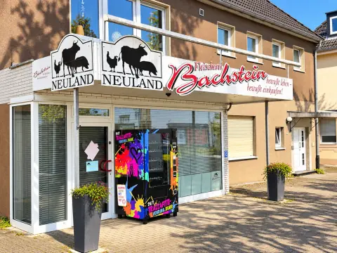 Bunt folierter TRALLAFITTI-Automat vor dem Schaufenster der Fleischerei Bachstein, Berghofer Straße 131 in Dortmund-Berghofen